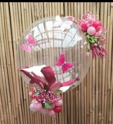 Transparent Balloon with butterflies on balloon and pink flowers on top and bottom tied with stick