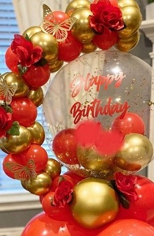 Clear happy birthday printed Balloon encircled with gold red balloons flowers and leaves