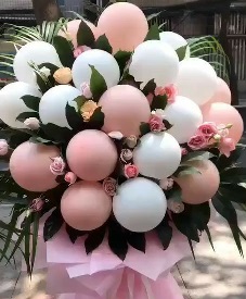 20 Blown up pink white balloons on sticks and 20 pink roses as fillers in a hand tied bouquet with pink paper wrapping