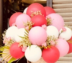 15 red white pink balloons arranged in basket with flowers